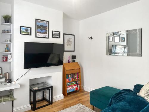 a living room with a couch and a flat screen tv at Miner's Rest in Rowrah