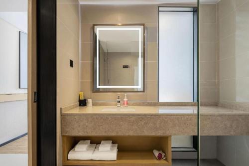 a bathroom with a sink and a mirror at City Comfort Inn Nanyang Nanshi Hospital in Nanyang