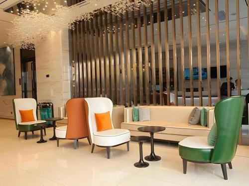 a lobby with chairs and tables in a building at City Comfort Inn Suzhou Wujiang Development Zone Yundong in Suzhou