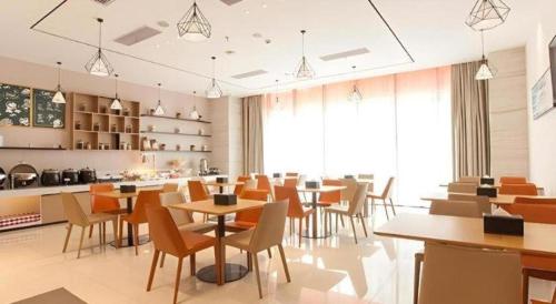 a restaurant with tables and chairs in a room at City Comfort Inn Suzhou Wujiang Development Zone Yundong in Suzhou