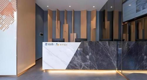 a lobby with a black marble counter and chairs at ZMAX Hotels Shenzhen Lianhuacun Metro Station in Shenzhen