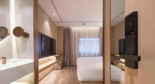 a hotel room with a bed and a television at ZMAX Hotels Shenzhen Lianhuacun Metro Station in Shenzhen