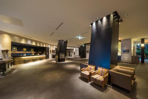 a lobby with couches and a stage in a building at Hotel Monterey Grasmere Osaka in Osaka