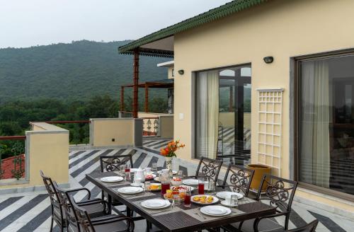 a table and chairs on a patio with a view at Dilip Niwas in Udaipur