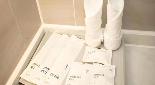 a white bathroom with toilet paper and towels at Lavande Hotel Shenzhen East Gate Wanxiang City Guomao Metro Statipn in Shenzhen