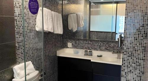 a bathroom with a sink and a toilet and a mirror at J Link Hotel in Hong Kong