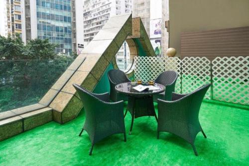 a patio with a table and chairs on a balcony at J Link Hotel in Hong Kong