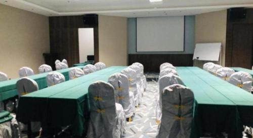 a conference room with a green table and chairs at Borrman Hotel Guilin Railway Station Two Rivers and Four Lakes in Guilin