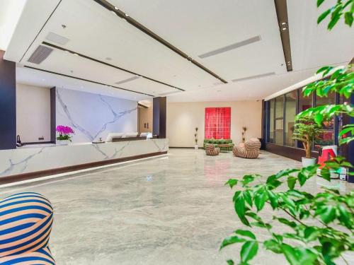 a large room with a lobby with plants at Borrman Hotel Chongqing Bishan Central Street in Chongqing