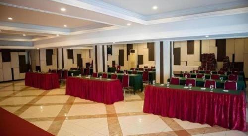 a large banquet hall with red tables and chairs at Karlita Hotel Tegal in Tegal