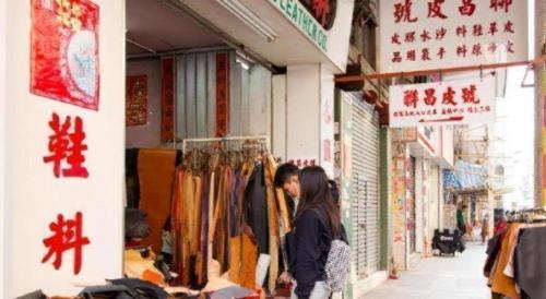 a woman standing in front of a clothing store at Metroplace Boutique in Hong Kong