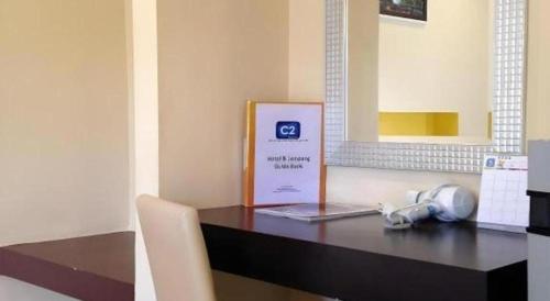 a table with a laptop and a sign on it at C2 Residence Hotel in Lampang