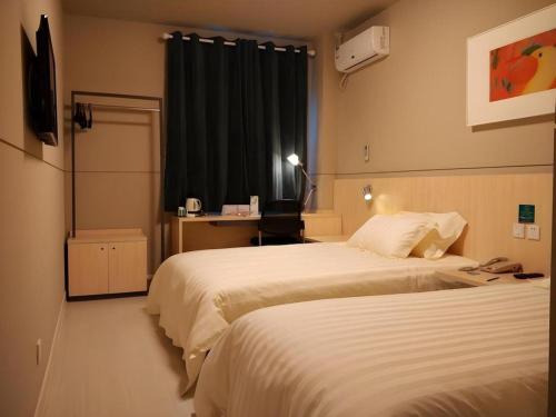 a hotel room with two beds and a window at Jinjiang Inn Shenzhen Airport in Shenzhen