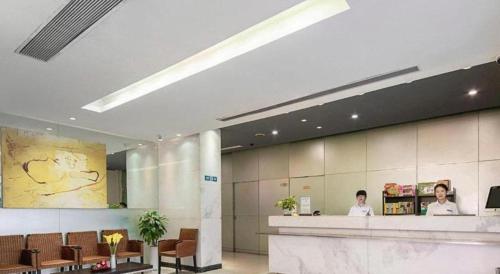 a lobby with two people sitting at a counter at Jinjiang Inn Shenzhen Airport in Shenzhen