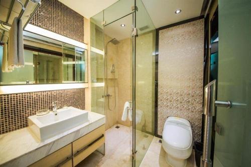 a bathroom with a sink and a toilet and a shower at Milu Hotel in Guangzhou