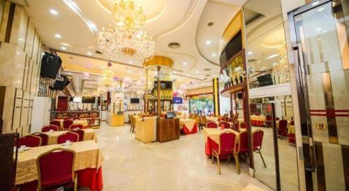 a restaurant with tables and chairs and a chandelier at Milu Hotel in Guangzhou