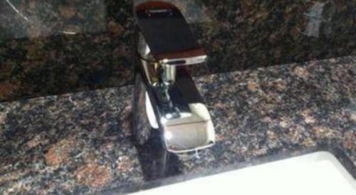 a cell phone in a holder on a counter at Pacific Motor Inn in San Jose