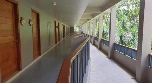 an empty hallway of a building with windows at River Kwai Village Hotel in Ban Kaeng Raboet