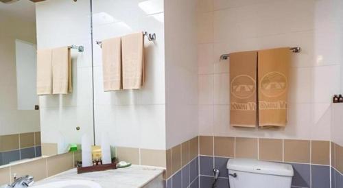 a bathroom with a toilet and a sink and a mirror at River Kwai Village Hotel in Ban Kaeng Raboet