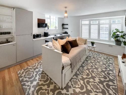 ein Wohnzimmer mit Couch und Küche in der Unterkunft Twin Pines in Kenley