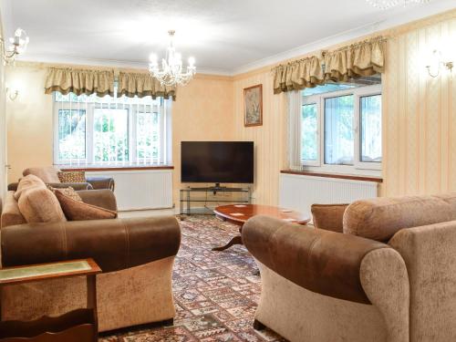 a living room with couches and a television at Quail Cottage - Uk50659 in Little Singleton