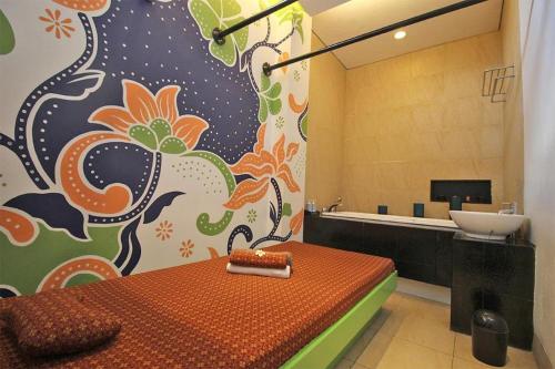 a bathroom with a bed and a sink in a room at Grand Surya Hotel Kediri in Kediri
