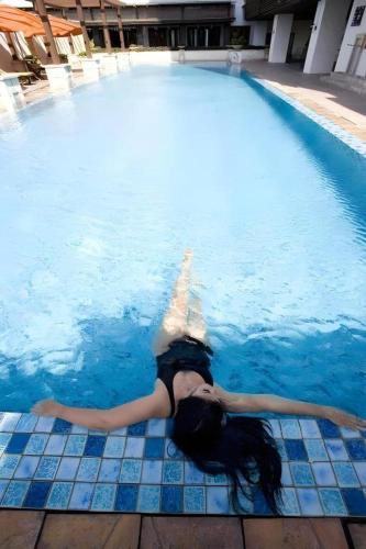 a girl swimming in a swimming pool at Grand Surya Hotel Kediri in Kediri