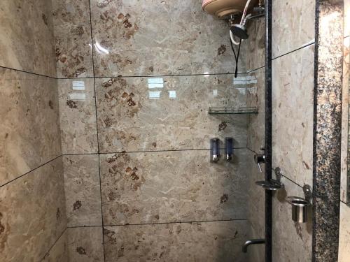 Un baño con ducha con puerta de cristal. en Cascade Villa Spacious 5BHK Luxury Villa, en Bangalore