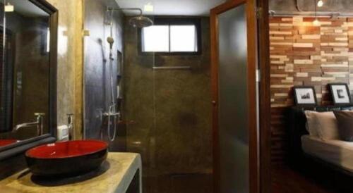 a bathroom with a red sink on a counter at Baan Hmon-Oon in Chiang Mai