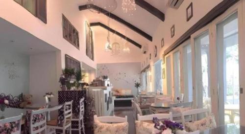 a large room with tables and chairs and windows at Baan Hmon-Oon in Chiang Mai