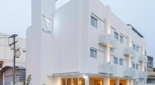 a white building with a sign on the side of it at 777Bliss Hometel in Nakhon Phanom