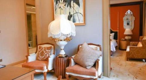 a living room with two chairs and a chandelier at Royal Tulip Hotel Zhujiajiao Shanghai in Shanghai