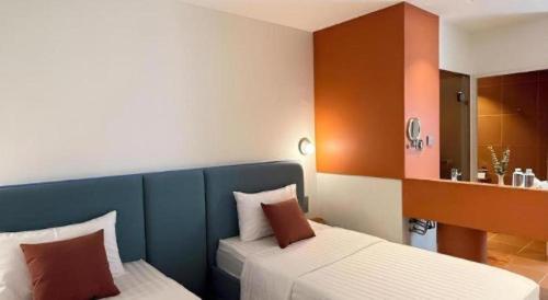a small bedroom with two beds and a mirror at 777Bliss Hometel in Nakhon Phanom