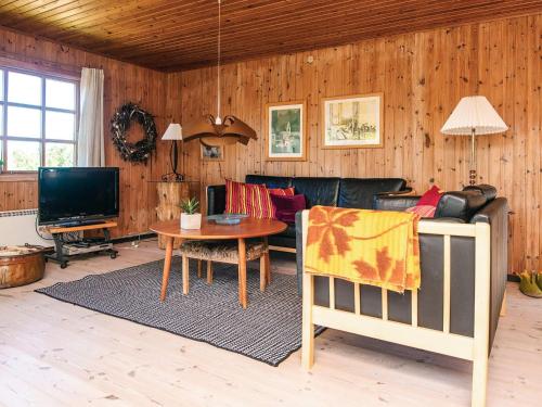 a living room with a couch and a table at 6 person holiday home in Rømø in Bolilmark