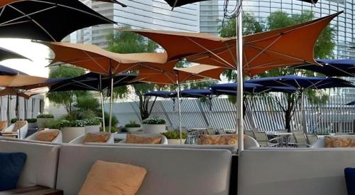 a group of umbrellas in a restaurant with tables and chairs at Luxury Suites International by Vdara in Las Vegas