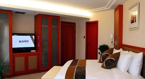 a bedroom with a large bed with a flat screen tv at Xian Qujiang Yinzuo Hotel in Xi'an