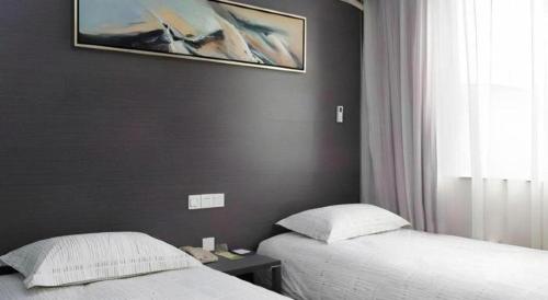 a bedroom with two beds and a painting on the wall at Goodrich Hotel in Hong Kong