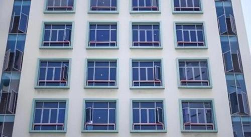 a tall white building with lots of windows at Darlene Hotel in Singapore