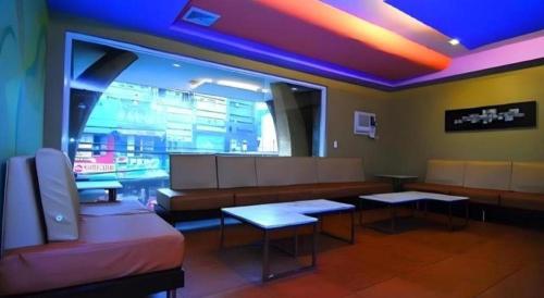 a waiting room with benches and tables in a building at MO2 Westown Hotel San Juan in Bacolod