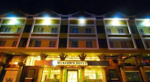 a hotel with a sign in front of it at night at MO2 Westown Hotel San Juan in Bacolod
