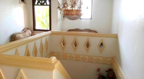 a staircase in a home with a chandelier at Khamsaner Hotel in Vientiane