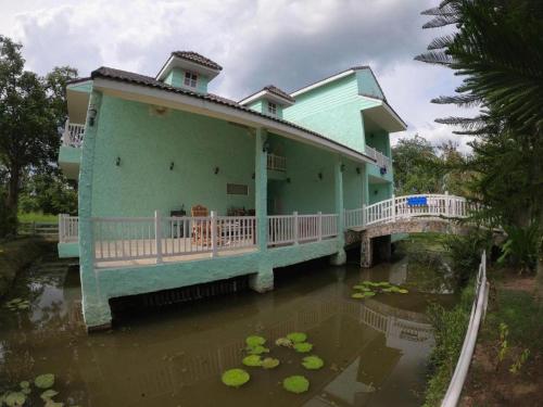 a house in the water with a lot at Charisma Resort in Ratchaburi