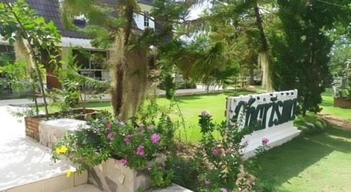 a garden with flowers in front of a building at Charisma Resort in Ratchaburi