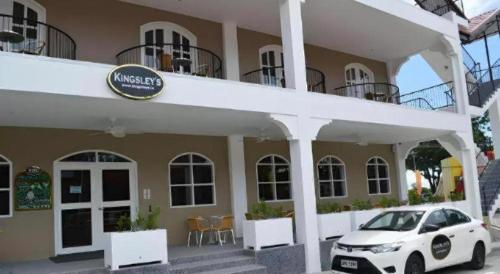 a white car parked in front of a building at Kingsleys Hotel and Gastro Pub in Angeles