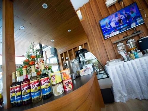 a bar with a counter with bottles of alcohol at GT Residence Hotel in Buriram