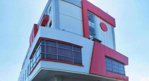 a red and white building with windows on it at Evora Hotel in Surabaya