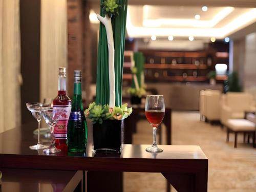 a table with glasses of wine and a vase with flowers at SUN Yat-sen university Hotel and Conference Centre in Guangzhou