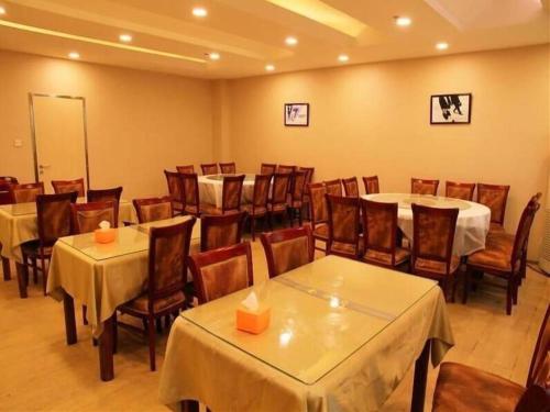 a dining room with tables and chairs in a room at GreenTree Inn Beijing East Yizhuang District Second Kechuang Street Express Hotel in Beijing
