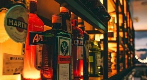 a row of bottles of alcohol on a shelf at Awesome Hotel in San Juan