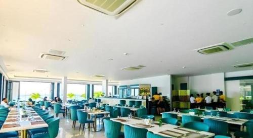 a dining room with blue chairs and tables and people at Awesome Hotel in San Juan